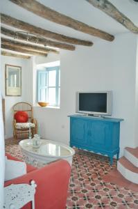 sala de estar con armario azul y TV en Casa Mosaico Granada en el V de Lecrin, en Nigüelas