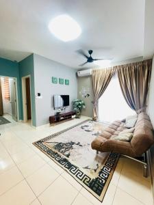 ein Wohnzimmer mit einem Sofa und einem TV in der Unterkunft E. R Homestay 3R2B nearby KLIA in Sepang