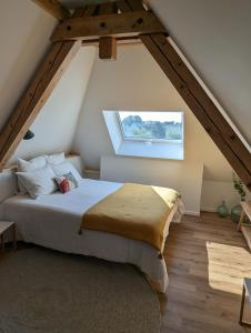 La Maison d'Enfance في Heimsbrunn: غرفة نوم مع سرير في العلية