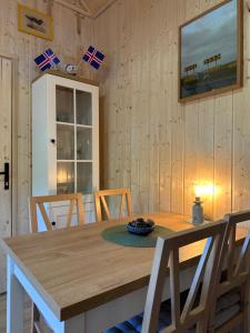a dining room with a wooden table and chairs at Islandzka chatka- Jacuzzi i sauna w cenie in Mżyki