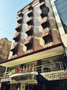 a tall building with balconies and flags on it at Hotel Süreyya in Istanbul