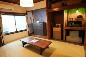 salon ze stolikiem kawowym i komodą w obiekcie つばめ荘 Tsubamesou w mieście Onomichi