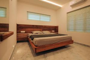 a bedroom with a bed with a wooden headboard at Redstone Villa in Tāzhekkod
