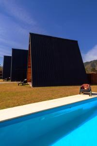 una casa con techo negro junto a una piscina en Las MORENAS en Yala