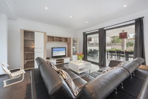 a living room with a leather couch and a television at Villa Lali in Alcudia