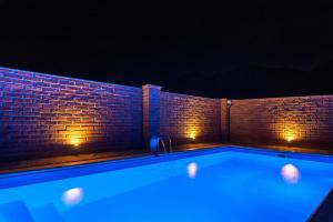 a hot tub with blue lighting in front of a brick wall at Las MORENAS in Yala