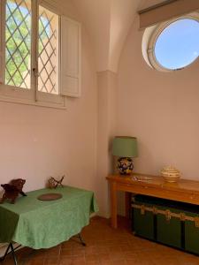 Cette chambre comprend une table avec une lampe et une fenêtre. dans l'établissement Palazzo Apostolico Orsini, à Lecce