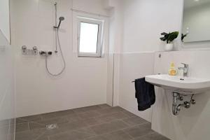 y baño blanco con lavabo y ducha. en Beautiful Apartment in Brachttal en Hellstein