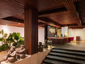 a lobby with statues and stairs in a building at The Bene Hotel in Kuta