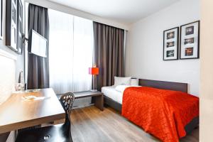 een hotelkamer met een bed, een bureau en een tafel bij Art & Business Hotel in Neurenberg