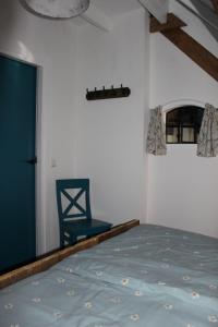 a bedroom with a blue bed and a blue chair at De hooizolder Hofstay195 in Achterveld