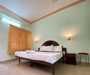 a bedroom with a large bed with white sheets at Packbag Comfort Bed & Breakfast in Kovalam