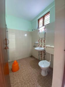 a bathroom with a toilet and a sink at Packbag Comfort Bed & Breakfast in Kovalam