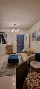 a living room with a couch and a table at Cassie Homestay - Yuna Door 2 - Furnished Home in Butuan in Butuan