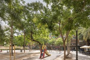 a park with trees and a playground with a slide at Macflats Ciudad de las Ciencias in Valencia