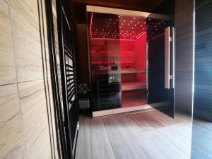 Holiday&wellness house Grofica في داروفار: باب زجاجي يؤدي إلى غرفة ذات أضواء حمراء