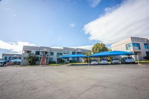 a parking lot with blue umbrellas in front of a building at @Villa de Vie holiday apartment in Cape Town