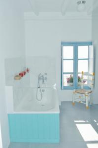 baño con bañera, silla y ventana en Casa Mosaico Granada en el V de Lecrin en Nigüelas
