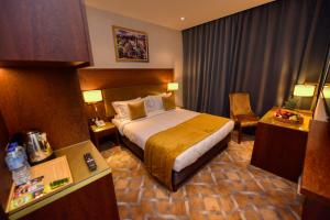 une chambre d'hôtel avec un lit et une chaise dans l'établissement LE PALME HOTEL, à Oran