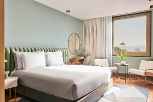 a bedroom with a large bed and a large window at Grand Hyatt Barcelona in Barcelona