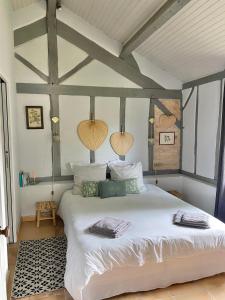 um quarto com uma grande cama branca num quarto em Domaine Au Bon em Angresse
