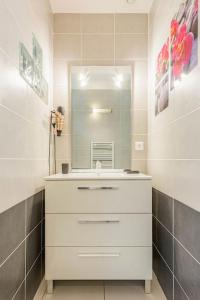 y baño con lavabo blanco y espejo. en Le Gîte du Doulac, en Saint-Omer