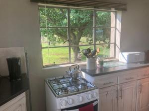 a kitchen with a stove and a window at Mountain View Cottage in Dullstroom