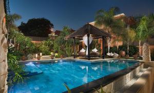 uma piscina com um gazebo ao lado de uma casa em Royal Garden Villas, Luxury Hotel em Adeje