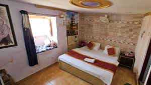 a bedroom with a large bed with a window at Nomadic Backpackers Hostel in Jaisalmer