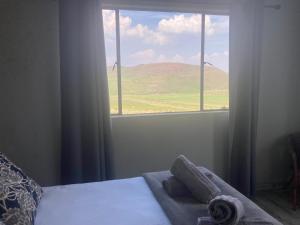 a bedroom with a window with a view of a mountain at Mountain View Farm Cottage 4X4 Vehicles ONLY in Dullstroom