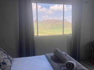 a bedroom with a window with a view of a mountain at Mountain View Cottage in Dullstroom