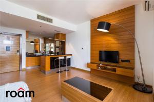 吉隆坡的住宿－Dua Sentral Kuala Lumpur by Roam，客厅设有木镶板和平面电视。