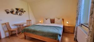 a bedroom with a bed and a table and chairs at Bungalow & Apartments "Am Deber" Velden - Augsdorf in Velden am Wörthersee