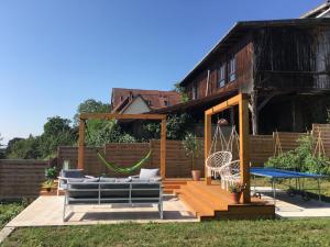 un patio con una hamaca y una casa en Au Relais de l'Histoire Gîte classé 4 étoiles, en Oberbronn