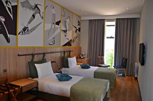 a hotel room with two beds and a tv at Arena Sport Hotel in Quba