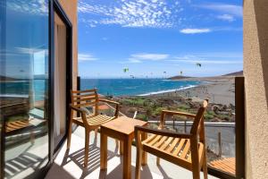 einen Balkon mit einem Tisch und Stühlen sowie Strandblick in der Unterkunft Hotel Playa Sur Tenerife in El Médano