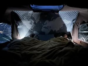 2 persone sdraiate in un letto in una tenda di Discovery 4 - Family Camper a Inshes