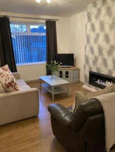 ein Wohnzimmer mit einem Sofa und einem Tisch in der Unterkunft Coniston House Lancaster 3 bedrooms Parking and Garden in Lancaster