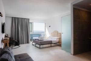 a bedroom with a bed and a desk in a room at Areti Hotel in Agia Galini