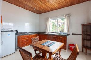 a kitchen with a wooden table and a white refrigerator at Chalets Cote Mer in Baie Sainte Anne