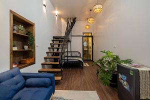 a living room with a blue couch and a staircase at Entireplace*2Br/Bathtub/SuperCenter*New* in Hanoi