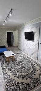 sala de estar con mesa y alfombra grande en 2-комнатная квартира, 55 м², 2/5 этаж посуточно, 8-й микрорайон, 8-й микрорайон 16, en Shymkent