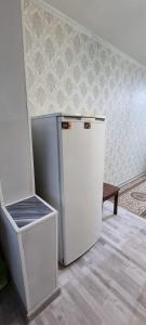 - białą lodówkę w pokoju ze ścianą w obiekcie 2-комнатная квартира, 55 м², 2/5 этаж посуточно, 8-й микрорайон, 8-й микрорайон 16 w mieście Szymkent