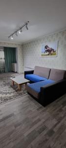 salon z kanapą i stołem w obiekcie 2-комнатная квартира, 55 м², 2/5 этаж посуточно, 8-й микрорайон, 8-й микрорайон 16 w mieście Szymkent