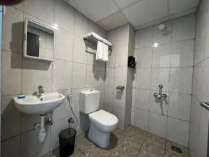 a bathroom with a toilet and a sink at U by Z Hotels, Bellandur in Bangalore