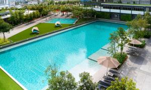 einen Blick über einen großen Pool mit Sonnenschirmen in der Unterkunft Perfect Rating Nexflix Jaya One Mall Seksyen 13 PJ in Petaling Jaya