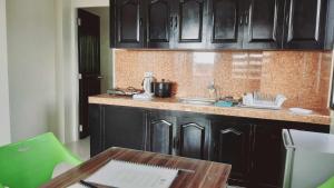 a kitchen with black cabinets and a wooden table at Avana Hills Boracay Prime Premiere Suite 104 in Boracay +18 photos
