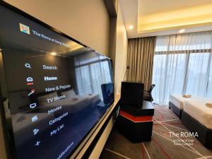 Zimmer mit einem großen Flachbild-TV in einem Hotelzimmer in der Unterkunft The Roma at Dang Wangi Kuala Lumpur in Kuala Lumpur