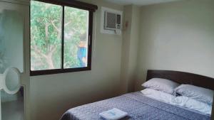 a bedroom with a bed and a window at Avana Hills Boracay Prime Premiere Suite 104 in Boracay