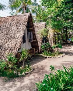 eine kleine Hütte mit Strohdach in der Unterkunft Georgia's Neverland Hostel in Malapascua